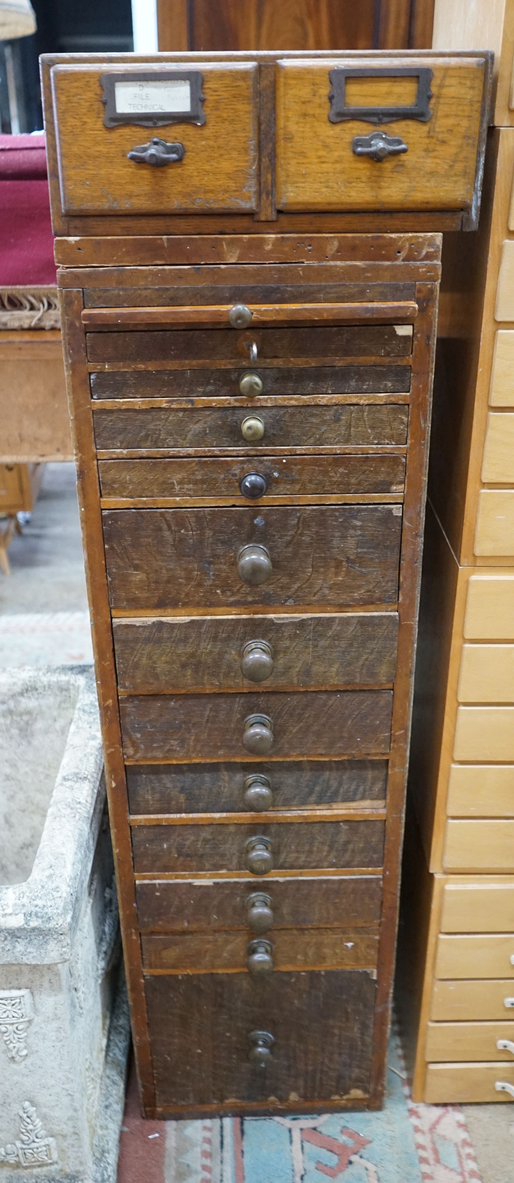 A vintage 11 drawer narrow chest containing assorted tools, height 108cm, together with an oak two drawer filing chest